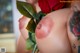 A woman with a tattoo on her arm holding a red rose.