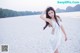 A woman in a white dress standing on a beach.