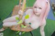 A woman with pink hair sitting on a swing.