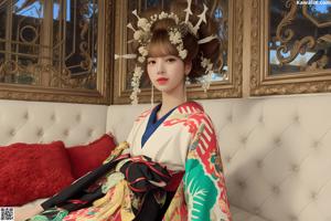 A woman in a kimono sitting on a white couch.