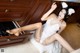 A woman in a white lingerie sitting on the floor in a kitchen.