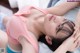 A woman laying on a bed with her head in her hands.