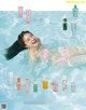 A woman in a pink bikini laying in a pool of water.